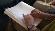 im Zug: Lesende Hände auf Braille schrift