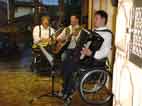 dreiköpfige Musikgruppe, zwei der Musiker sitzen im Rollstuhl