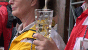 Dubbeglas mit Weinschorle in Volkhards Hand, dahinter Marlene