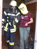Feuerwehrmann mit zu rettender Person , die eine schutzhaube trägt.