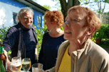 Bernd, Angela, Margit am Stehtisch mit Gläsern in der Hand