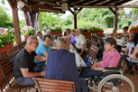 am Tisch auf der Terrasse im Vordergrund Erik, Udo, Jörg von Hinten, Annette im Rollstuhl