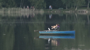 Zwei Mädchen in einem Boot auf dem See, die die Melodien ins Horn blasen