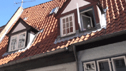 Blick auf das mit roten Ziegeln gedeckte Dach eines der Häuschen mit Dachgauben